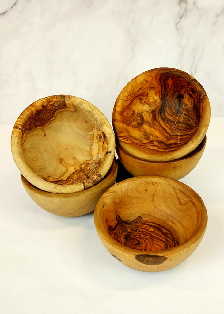 A set of five olive wood salad bowls, each showcasing unique natural grain pattern