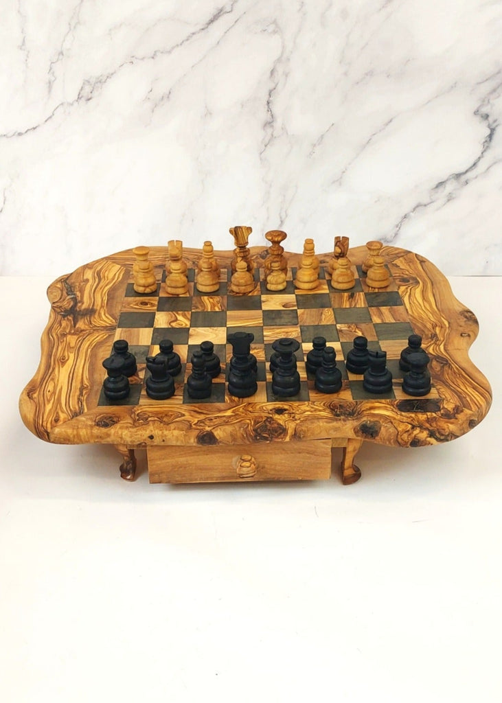 an olive wood chess board with legs and drawers featuring black and brown squares, paired with handcrafted black and brown olive wood chess pieces