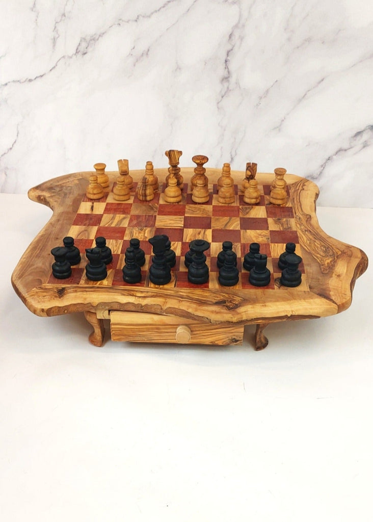 an olive wood chess board with legs and drawers featuring red and brown squares, paired with handcrafted black and brown olive wood chess pieces