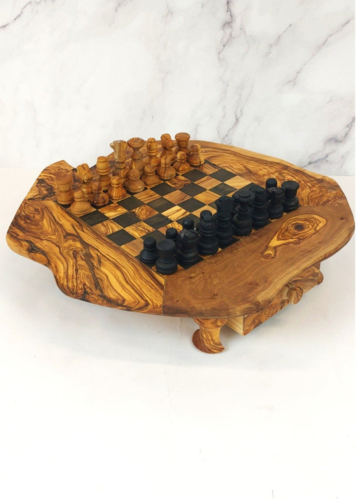 an olive wood chess board with legs and drawers featuring black and brown squares, paired with handcrafted black and brown olive wood chess pieces