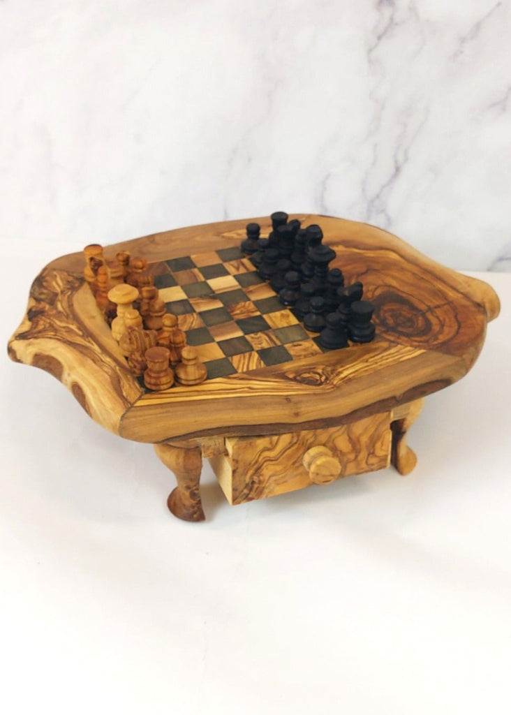 an olive wood chess board with legs and drawers featuring black and brown squares, paired with handcrafted black and brown olive wood chess pieces