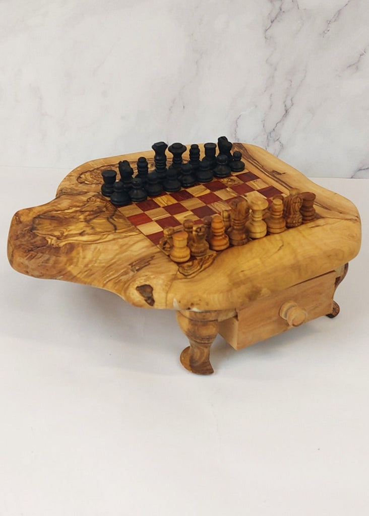 an olive wood chess board with legs and drawers featuring red and brown squares, paired with handcrafted black and brown olive wood chess pieces